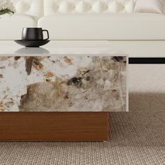 a marble coffee table in front of a white couch