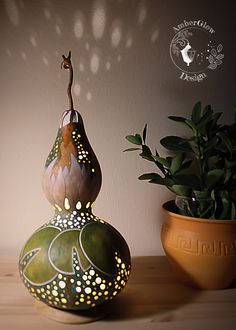 a potted plant sitting on top of a wooden table next to a ceramic vase