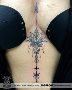 a woman's breast with an intricate tattoo design on her chest and the back