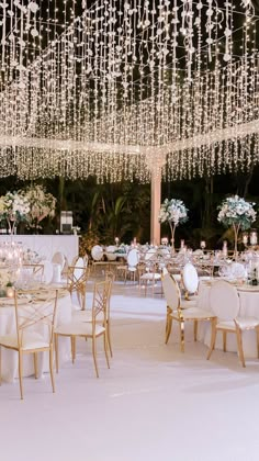 an outdoor wedding reception with chandeliers and tables