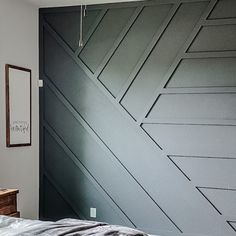 a bed sitting in a bedroom next to a wall with geometric designs on the walls