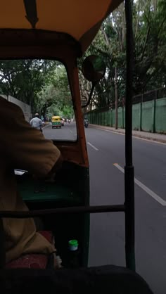 a man driving a green truck down a street