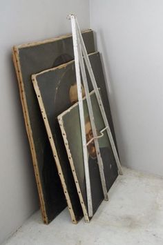 three frames are stacked on top of each other in an empty room with white walls