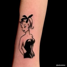 a woman's arm with a tattoo on it that looks like she is wearing a black dress