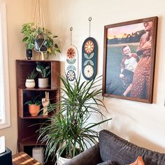 a living room with plants and pictures on the wall