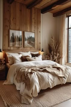 a bedroom with wood paneled walls and white bedding, two framed pictures on the wall