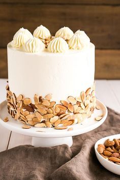 a white cake topped with almonds and frosting