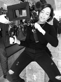 a woman sitting on top of a counter next to a camera