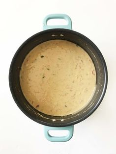 a pan with some food inside of it on a table next to a white wall