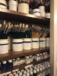 there are many jars and brushes on the shelves