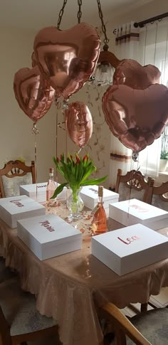 the table is set with several boxes and balloons