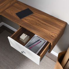 a wooden desk with an open drawer on the bottom and a tablet computer in it