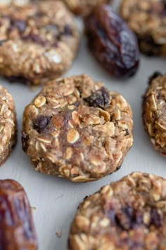 several cookies with nuts and raisins sitting on top of a white countertop