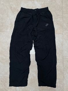 These pants are super hip and comfortable. They've got that full wide leg more baggy look, which is back. They are old school Nike. They must be bought to be worn.  Brand: Nike Size: Large Material: Polyester nylon cotton Measurements in inches Waist 32-36 Inseam 32 1/1.9 #21 I do accept returns within 30 days of purchase of all vintage items. The item must be in the same condition in which it shipped and preferably with the tags still on. The customer is responsible for all shipping costs and there is a 20% restocking fee for all returns. 90s Wide Leg Parachute Pants For Streetwear, Vintage Nike Clothing, Nike Vintage Pants, Sportswear Style Parachute Pants For Streetwear, Athleisure Solid Parachute Pants For Streetwear, Solid Athleisure Parachute Pants For Streetwear, 90s Parachute Pants For Streetwear, Nike 2000s, 90s Style Black Sports Pants