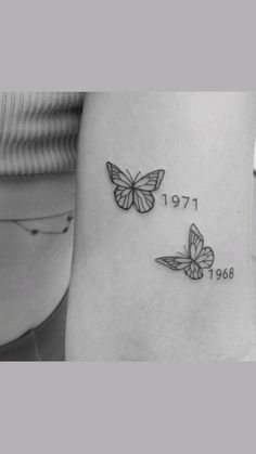 two butterflies on the side of a woman's leg with her name written in black ink