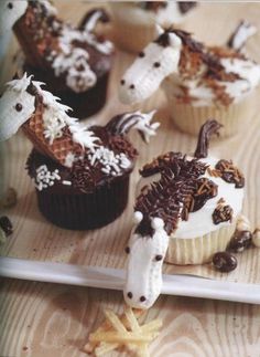 some cupcakes with horses on them sitting on a tray