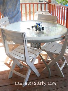 an outdoor table and chairs on a deck