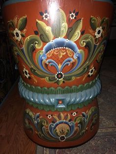 an ornately painted vase sitting on top of a wooden table