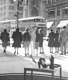 black and white photograph of people walking down the street