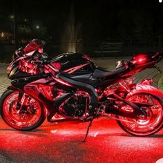 a red motorcycle parked on the street at night