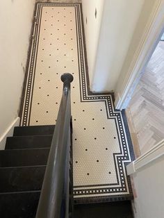 an image of a stairway with black and white tiles on the floor in this house