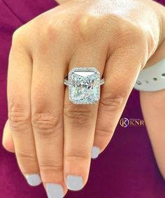 a woman's hand with a ring on her finger and a diamond in the middle