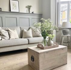 a living room filled with furniture and flowers on top of a coffee table in front of a couch