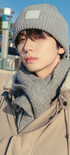 a young man wearing a gray hat and scarf