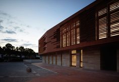 an empty parking lot next to a building with wooden slats on the front and sides