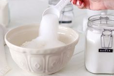 a person using a toothbrush to brush their teeth in front of a glass jar