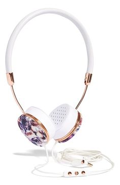 the headphones are white and gold with floral designs on them, along with ear buds