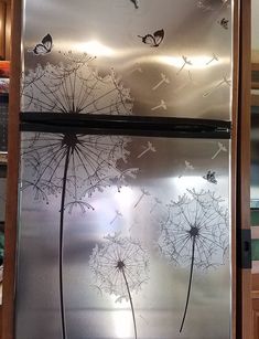 a stainless steel refrigerator with dandelions etched on it