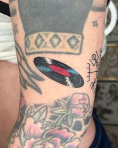 a person with a tattoo on their arm has a record in the middle of it