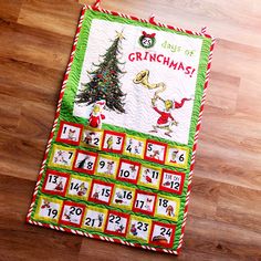 a christmas calendar on a wooden floor with a santa clause tree in the middle and numbers below it