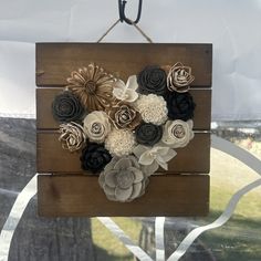 a wooden sign with paper flowers on it