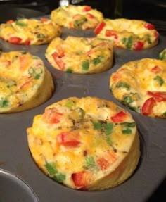 several muffins with different toppings sitting in a pan on top of a stove