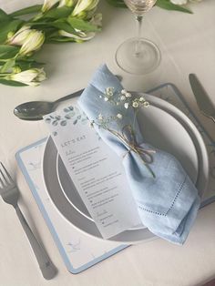 a place setting with napkins, silverware and flowers