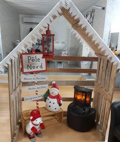 a house made out of wood with a snowman in the front and a christmas decoration behind it