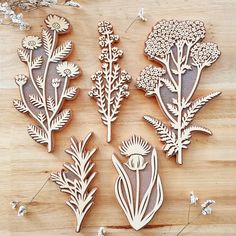 several wooden cutouts of flowers and plants on a table