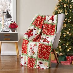 a living room with a christmas tree in the corner and presents on the floor next to it