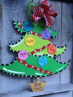 a christmas tree made out of cardboard with buttons on it and a bow hanging from the top