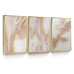 three gold and white paintings hanging on the wall in front of a white background, each with