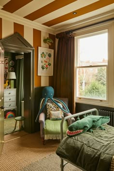 a bedroom with striped walls and green bedding in the foreground, an elephant shaped chair on the far end