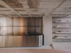 an empty kitchen with stainless steel cabinets and shelving units in the back ground area