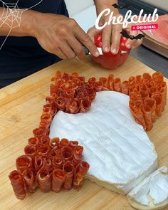 a person cutting up food on top of a wooden table