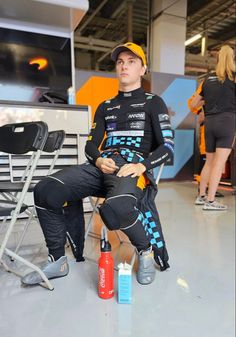 a man sitting on top of a chair next to two bottles