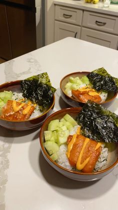 three bowls filled with food sitting on top of a counter next to a sink and oven