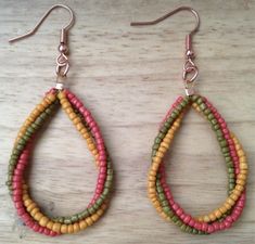 two pairs of beaded earrings on top of a wooden table