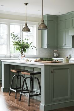 a kitchen with green cabinets and stools