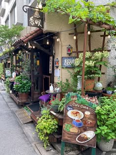 an outdoor cafe with potted plants on the outside